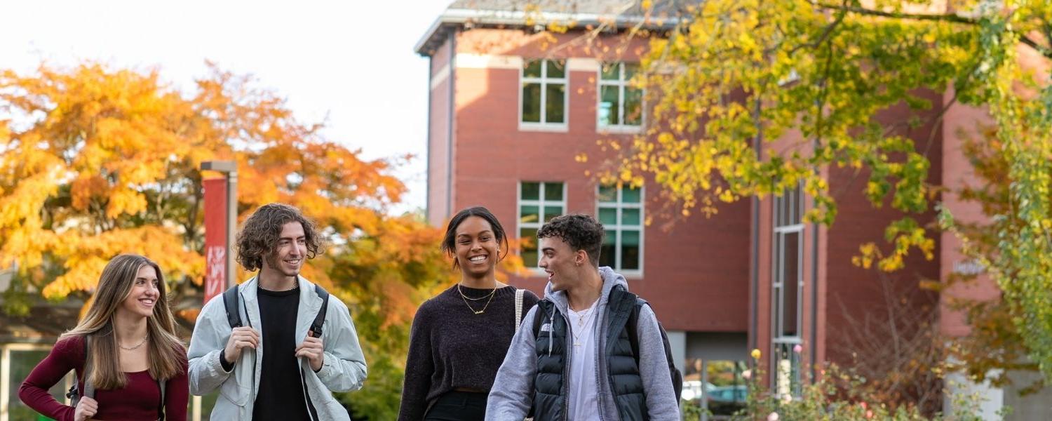 Four SPU students, 三个男学生和一个女学生, 走在校园里，背景是伊顿科学楼.
